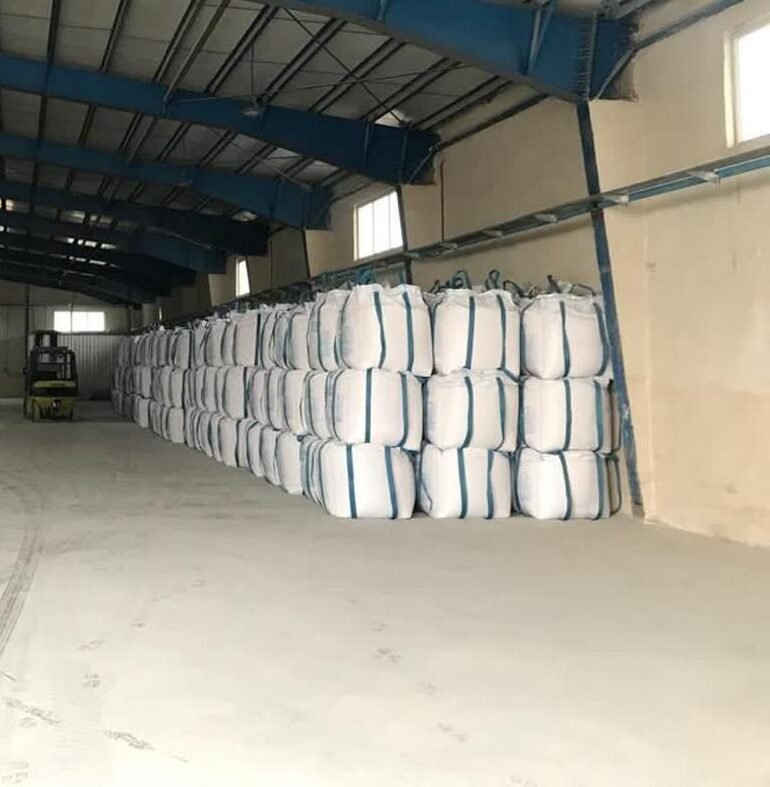 Large scale warehouse storage of high-purity industrial salt in jumbo bags for global export.